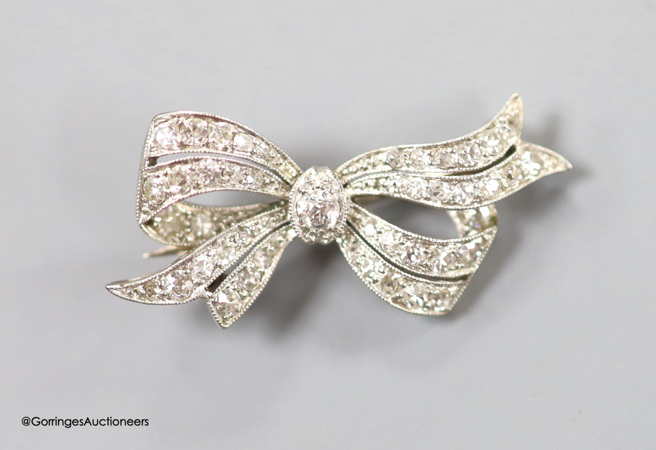 A 1920's/1930's white metal and diamond set bow brooch, 32mm, gross weight 4.5 grams.
